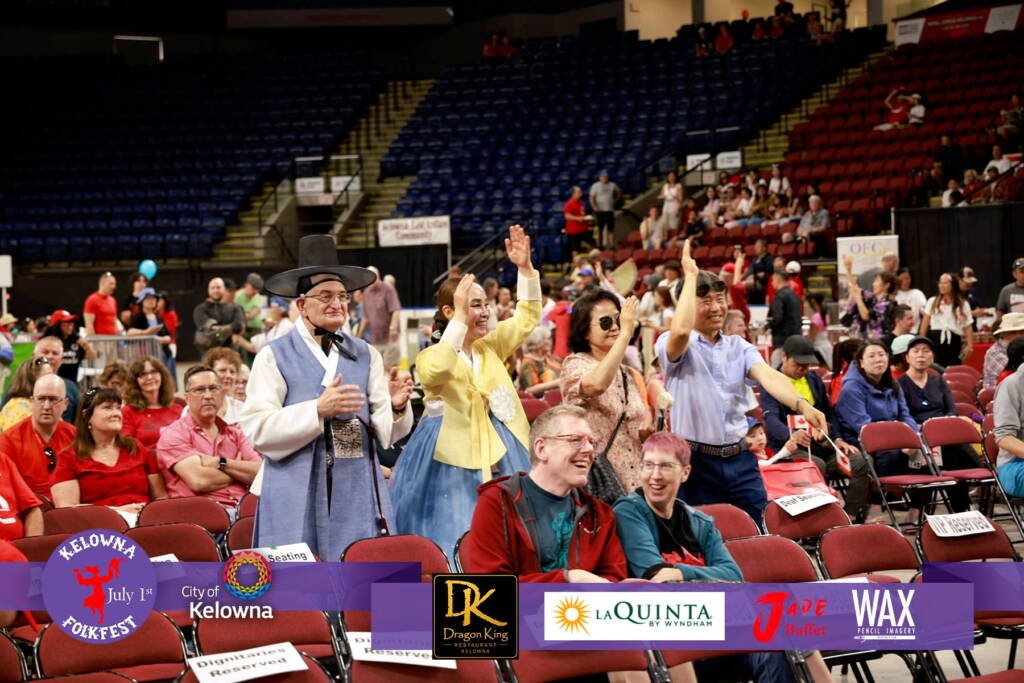 Paul Lauzon and his wife waving during Kelowna Folkfest at Prospera Place on Canada Day 2026
