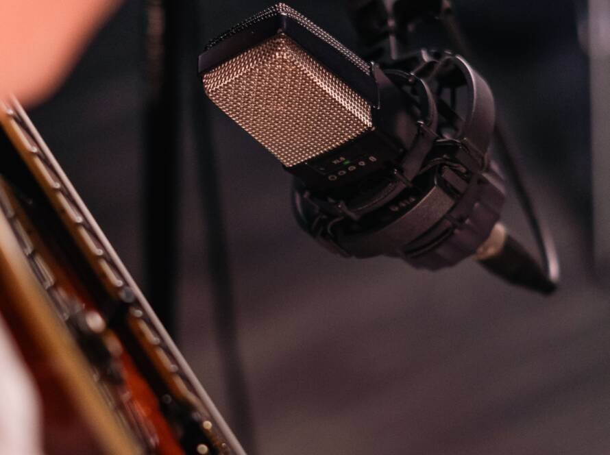 Close-up of an acoustic guitar being recorded with a studio microphone