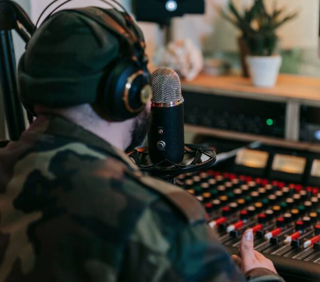 Musician wearing headphones at a recording studio mixing console
