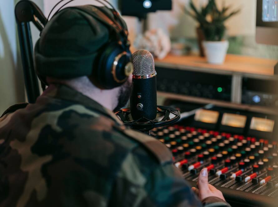 Musician wearing headphones at a recording studio mixing console
